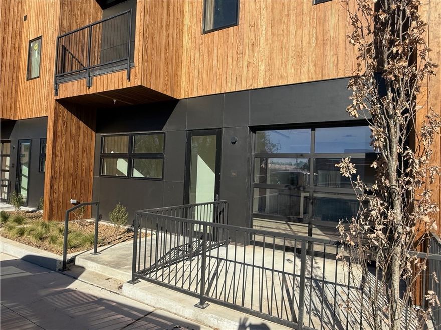 Luxury one-bedroom condo with office in the brand-new The Haven Bentonville, a 29-unit boutique condominium positioned between the Bentonville Square and the Walmart Home Office. This main-level residence features a private exterior entrance, making it eligible for short-term rental use. Thoughtfully designed interiors include white oak cabinetry with a rich walnut stain, modern quartz countertops, and premium Bosch appliances—slide-in induction range, counter-depth refrigerator, ultra-quiet dishwasher, and in-unit washer and dryer. High ceilings and expansive windows fill the space with natural light, while a full-glass garage door in the living area creates seamless living. Solid 8' doors, Brizo plumbing fixtures, and a dedicated pantry elevate both style and function. The bedroom easily accommodates a king-size bed and includes a generous walk-in closet with custom built-ins. A rare opportunity for refined, lock-and-leave living or investment ownership in one of downtown Bentonville’s newest luxury offerings.