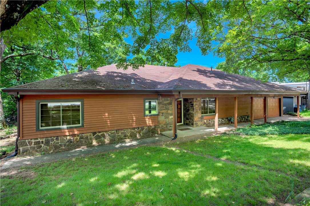 Perched on the scenic slopes of Mt. Sequoyah, this true Fayetteville gem offers timeless charm & breathtaking views. The striking exterior pairs redwood siding with native stone, creating standout curb appeal that complements its natural surroundings. Inside, youāll find original white oak hardwood floors, knotty pine paneling, & 2 inviting fireplacesāeach with a dual-function wood-burning stove. The den features a Vermont Castings stove, while the living room boasts a Soapstone Wood stove. A heated and cooled Four Seasons sunroom invites year-round enjoyment of the outdoors. Updates throughout the home include new carpet in the Main bedroom & new LVP flooring in the kitchen & den, while the kitchen contains a brand-new oven. The family bath offers a spa-like feel with travertine tile and an American Standard jetted tub with inline water heater. Native stone flower beds add to the homeās unique character. This is a rare opportunity to own an original Mt. Sequoyah home.