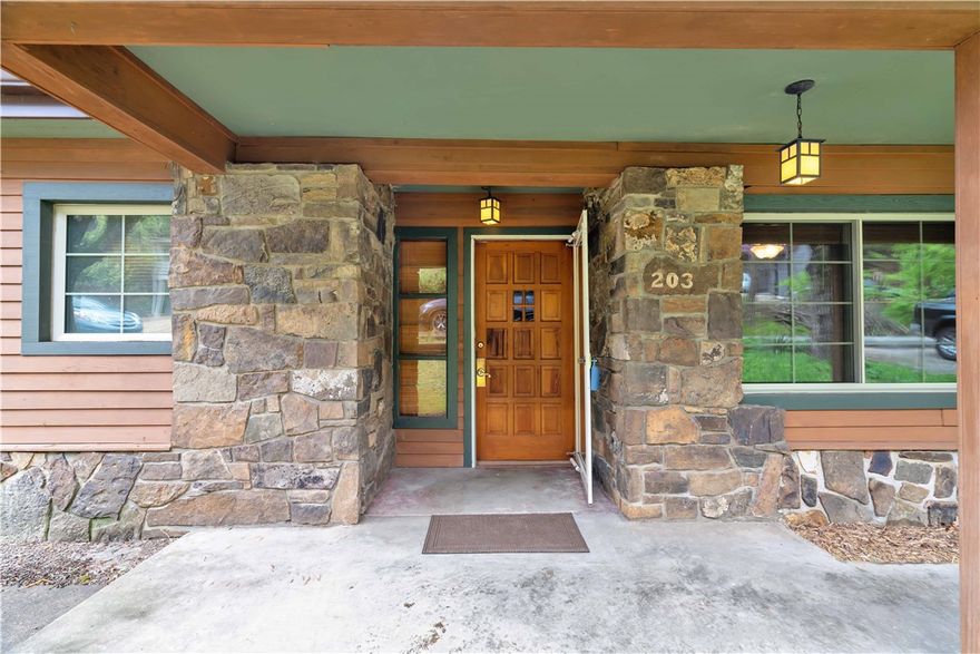 Perched on the scenic slopes of Mt. Sequoyah, this true Fayetteville gem offers timeless charm & breathtaking views. The striking exterior pairs redwood siding with native stone, creating standout curb appeal that complements its natural surroundings. Inside, you’ll find original white oak hardwood floors, knotty pine paneling, & 2 inviting fireplaces—each with a dual-function wood-burning stove. The den features a Vermont Castings stove, while the living room boasts a Soapstone Wood stove. A heated and cooled Four Seasons sunroom (178 sq ft, not included in sq ft) invites year-round enjoyment of the outdoors. Updates throughout the home include new carpet in the Main bedroom & new LVP flooring in the kitchen & den, while the kitchen contains a brand-new oven. The family bath offers a spa-like feel with travertine tile and an American Standard jetted tub with inline water heater. Native stone flower beds add to the home’s unique character. This is a rare opportunity to own an original Mt. Sequoyah home.