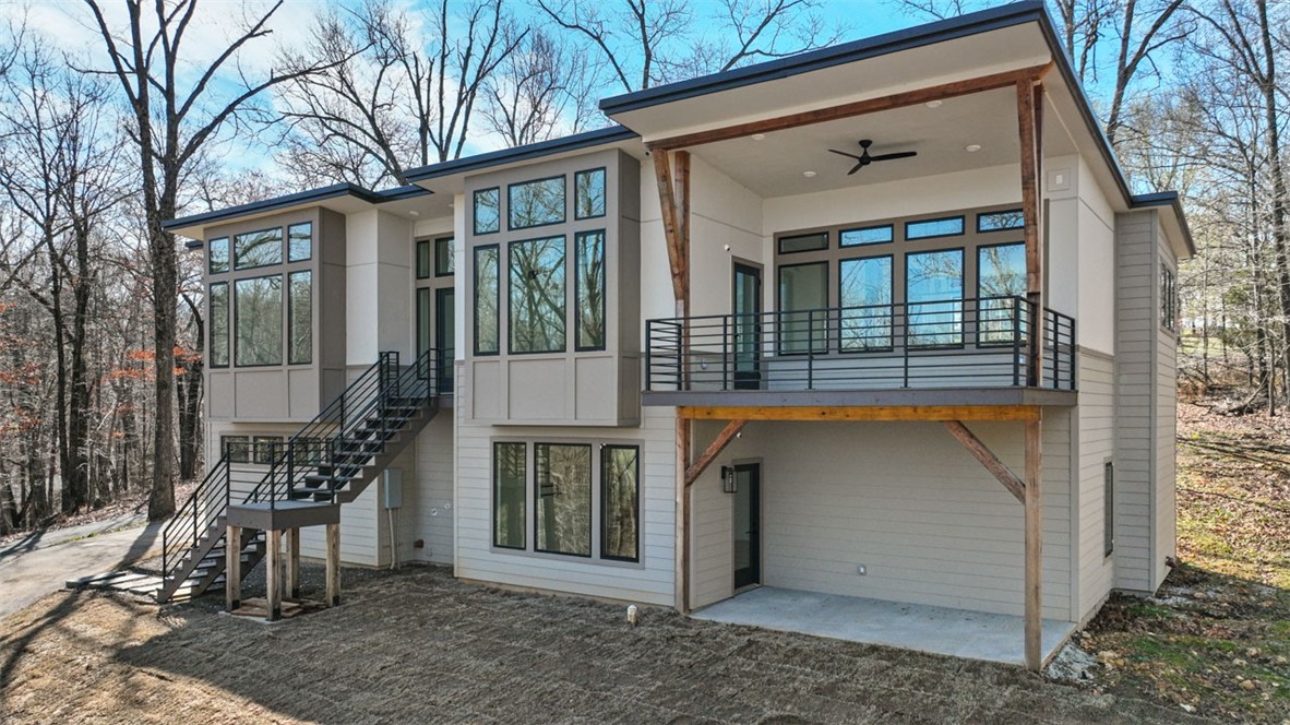 Location is key to the 2022 custom built home on 3 acres!!!, 3 miles to downtown Rogers and right between Lake Atalanta and Beaver Lake ,feel like you are worlds away. The natural light in this house will fill your day with amazing sunshine. Lots of upgrades throughout this build, with additional insulation and interior soundproofing, tankless water heater, soft close cabinets, and fully integrated home network, additional items added 2024, new natural stone entry and sod, fresh paint throughout and a new filtration system. Enjoy not 1 but 2 amazing covered porches to enjoy the abundant wildlife in your own front yard. Washer/Dryer, Refrigerator, and deep freeze, TV mounts all will convey. 2 large Living areas one main floor one down stairs. Don't miss your chance to see this amazing unique home.