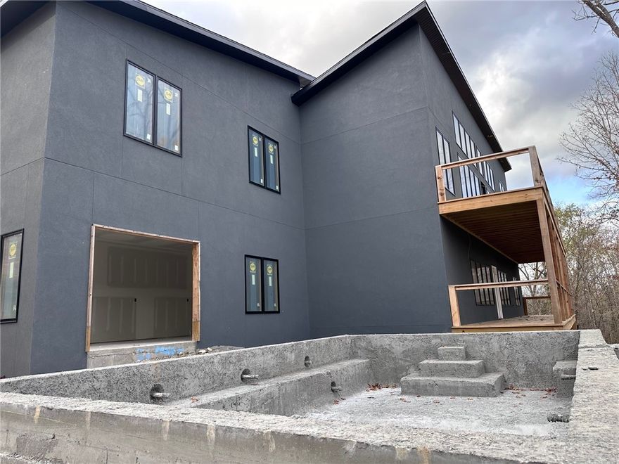 Welcome to paradise in Bella Vista, Arkansas! This stunning, modern home offers breathtaking views from nearly every room, set amid nature’s beauty. Featuring a heated 15’x24’ gunite pool with a dedicated pool room, this space boasts a roll-up glass door, wet bar, and versatile layout perfect for a gym. The home’s sleek design combines a single slant roof, rock and stucco exterior, and exceptional lighting throughout. The kitchen showcases white oak and painted cabinetry, quartz countertops, and premium appliances, including a 6-burner Wolf gas cooktop, and opens to a spacious great room with a wall of windows and a modern gas fireplace. The main level hosts the primary suite with a spa-like bath, a guest suite, and a laundry room. The lower level offers another guest suite, office, family room, second laundry room, ample storage, and pool access. Blending luxury with functionality, this home is truly a retreat you’ll never want to leave!