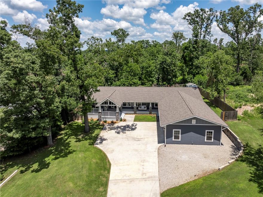 Not far from Downtown Bentonville, trails / bike paths & very close to I-49, this newer 2020 1-story, full hardie board, craftsman & traditional styled home is privately situated in a woodsy setting on almost half an acre, w/4-bedrooms, 3-baths, 2-car attached roomy garage, landscaped front yard w/large covered porch that boasts an oversized comfy porch swing/wood beamed cathedral ceiling/circle wrought iron chandelier, & an open backyard deck, wooded views from front or back yards, shed for lawn equipment/storage/or make it a he/she shed, entry foyer leads into open living room/dining/kitchen areas, butler pantry & separate laundry room both w/barn doors & located between the kitchen & primary suite, big kitchen island for food prep & dining space, gas burner stove w/pot-filler faucet, appliances convey, closet built-ins, extra gravel parking.  So many features too numerous to mention.  Roof 2025, HVAC system & Hot Water Tank from 2019-2020, in working condition & Seller offering a Home Warranty.