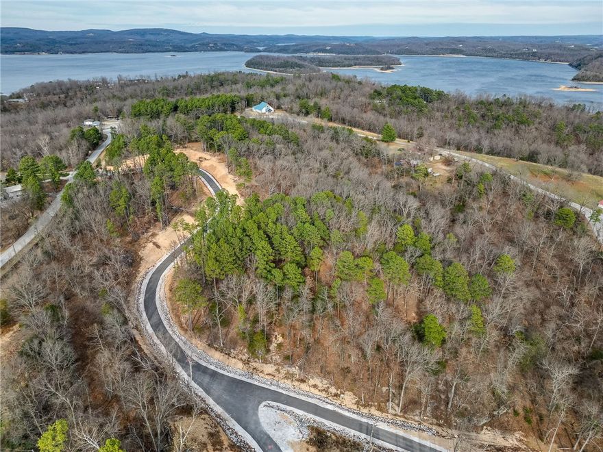 Discover the perfect canvas for your dream retreat or primary residence just moments from beautiful Beaver Lake. This sloped lot offers a serene natural setting surrounded by mature trees and peaceful privacy of the Ozarks. With electricity and water at the street and easy access on well-maintained asphalt roads, the property is ideally positioned for full-time residence, vacation home, or investment build. Enjoy quick access to boating, fishing, and scenic trails in the Hobbs State Park...while still being within a short drive of Rogers and Bentonville with all their conveniences. A rare opportunity to secure your own slice of the Beaver Lake Lifestyle.