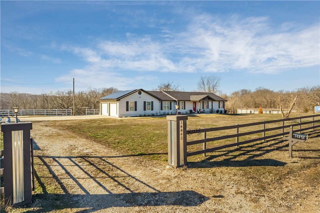 Located near Highway 72 and I-49. This beautifully gaited and remodeled single-family home is set on a picturesque 5-acre lot. Built in 1990, this residence offers 1532 square feet of open living space, featuring 3 bedrooms and 2 bathrooms. The interior boasts real hardwood flooring in the main living areas, a custom built-in mud bench, a modern kitchen with granite countertops, a pantry, a center island, and stainless steel appliances. Both bathrooms have been updated with tiled showers and modern cabinetry. Additional improvements include a new roof and a new HVAC unit in 2022. The septic was also pumped in 2022. One horse barn with tack room and corral/run. Solar panels on home (paid for). In the back of the property, a single-wide trailer could be renovated and looked at for a potential rental property or storage. There is no info on this trailer or the septic. It has been there for over 23 years.