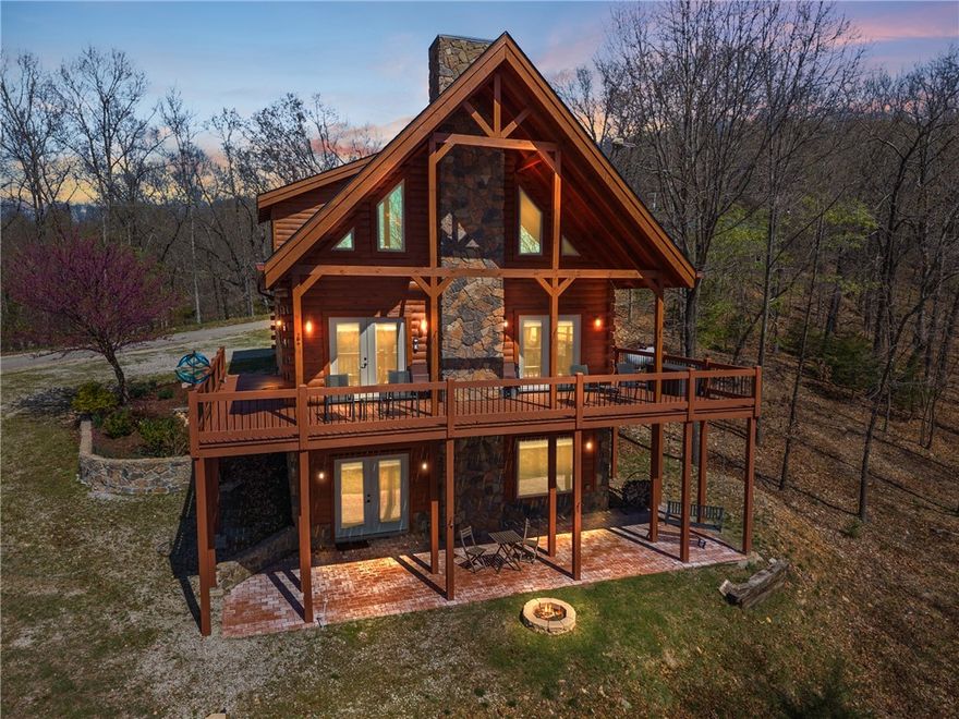 Custom 3-level log home on 6.47 acres with panoramic views of Beaver Lake. Built in 2017 by Battle Creek Log Homes, this 2,448 sqft home features 3 bedrooms (including 2 spacious suites), 3.5 baths, a lower-level bonus space for office/family room, and a loft suite with its own private sitting area or office space. Vaulted ceilings, walk-out basement, granite kitchen with high-end Jenn-Air appliances, gas cooktop, microwave/convection combo, pantry closet, and bar seating. Quality finishes throughout: hardwood, tile, and carpet flooring, custom blinds, and two gas fireplaces. Bathrooms include granite double vanities and custom tile showers with glass doors. Private well, septic system, tankless water heater, and 24kW whole-house Generac generator with transferable warranty. 30x44 red iron insulated shop (2019) perfect for all the lake toys with 16’ walls, RV/boat auto door, wired for 110V and 220V. 20x11 storage building. New roofs on both shops and home all in 2024. Don't miss out on this incredible opportunity!
