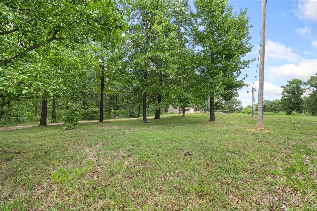 Discover your private escape on 40+ secluded, wooded acres at the end of a quiet private road—perfect for building your dream home. An excavated building site extends the length of the driveway and plans for a 5,000 sq ft house are included. Rural water, supplied by SPG, is already on with outdoor faucets in place, and electricity with an active 50-amp outlet is installed. The septic system supports up to 6 bedrooms, and a 500-gallon propane tank is buried and filled. A separate pad for a 40x60 shop is excavated, with red dirt ready for backfill. Several maintained trails wind through the property, leading to a hunting stand that stays. A locking shed sits on a concrete slab, and a level spot is ideal for a chicken coop. Abundant wildlife makes this property perfect for hunters or anyone who wants to enjoy nature—the possibilities are endless!