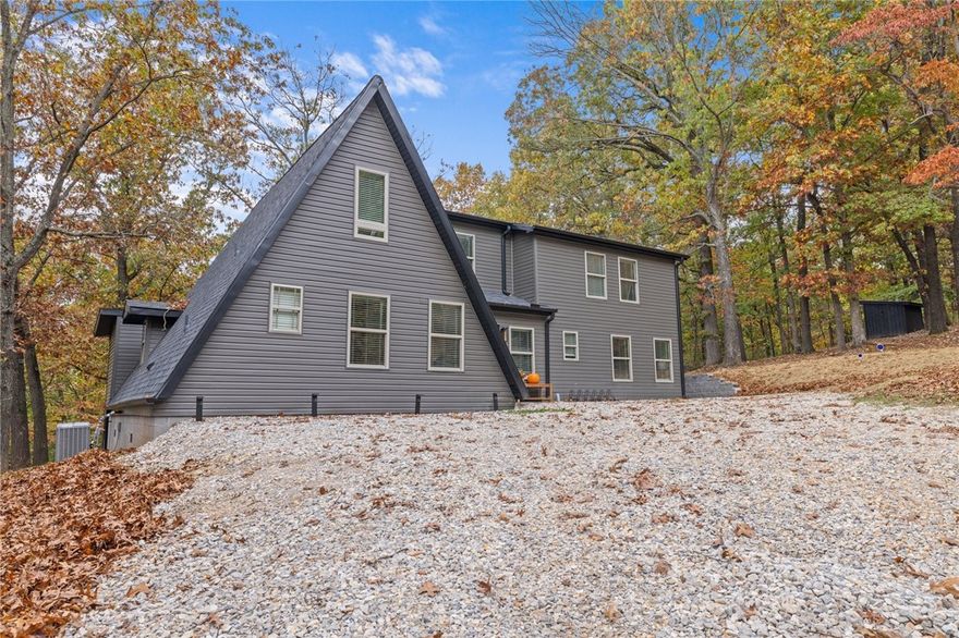 Welcome to your ultimate retreat for outdoor lovers and mountain bikers! Thriving as an Airbnb, this A-frame can also be your primary residence. Set on 2 acres near Slaughter Pen and Hand Cut Hollow MBTs, it's recently remodeled and spans 2,434 sqft. Each of the 3 bedrooms has its own bathroom, and the living room features soaring 20-ft ceilings and a guest half bath. Close to Fly Oz Airstrip and the original Format Festival site, it includes a detached 2-car garage with ample parking. The kitchen has retro appliances, and there's a dining area and loft ideal for planning biking adventures. Available fully furnished for an additional cost.