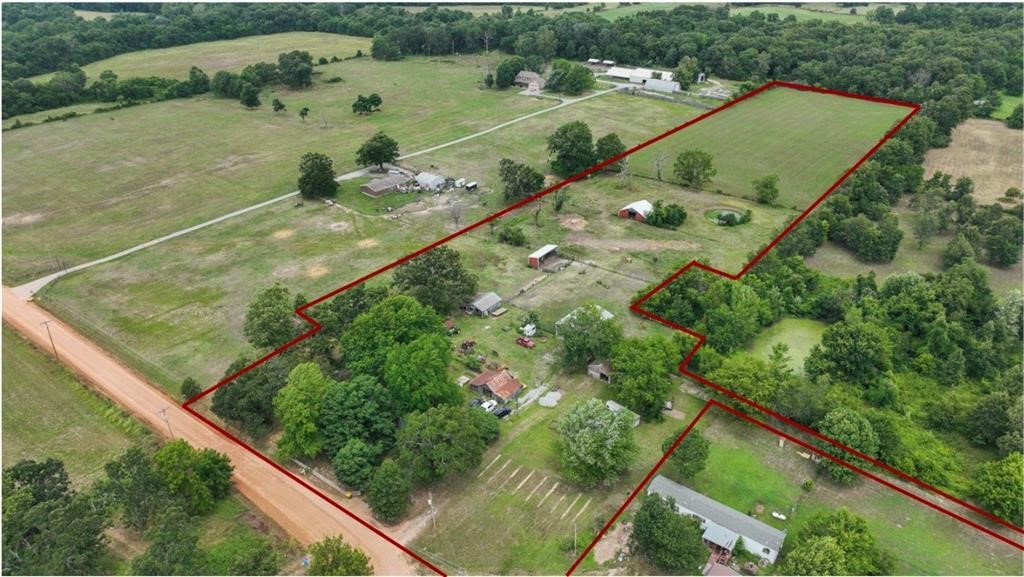 Incredible investment opportunity in up-and-coming Centerton, AR! This mostly cleared 9.99 acres is soon to be annexed into Centerton city limits. Zoned res. and agricultural but will be medium-to-high
density residential. Dirt road will be paved/maintained by the city. Other plans include residential developments and a community center nearby. Sewer will be accessible with new subdivision to Southeast. Ever dream of remodeling your own historic farmhouse with fantastic bones? Kitchen updated in 2021 with new cabinets, countertops, and a Bluetooth-enabled induction stovetop; new HVAC/ductwork in 2022; new water heater; upgraded plumbing; updated 200 amp wiring with GFCI protection; new soapstone wood stove; Nest thermostat; and new energy-efficient tilt windows. Numerous outbuildings (some w/electric & water access) including well house, barn, shop, 3-stall loafing shed, storage buildings, and powered/lighted RV-ready carport with roll-up door; Centaur White Lightning fencing runs through the property.