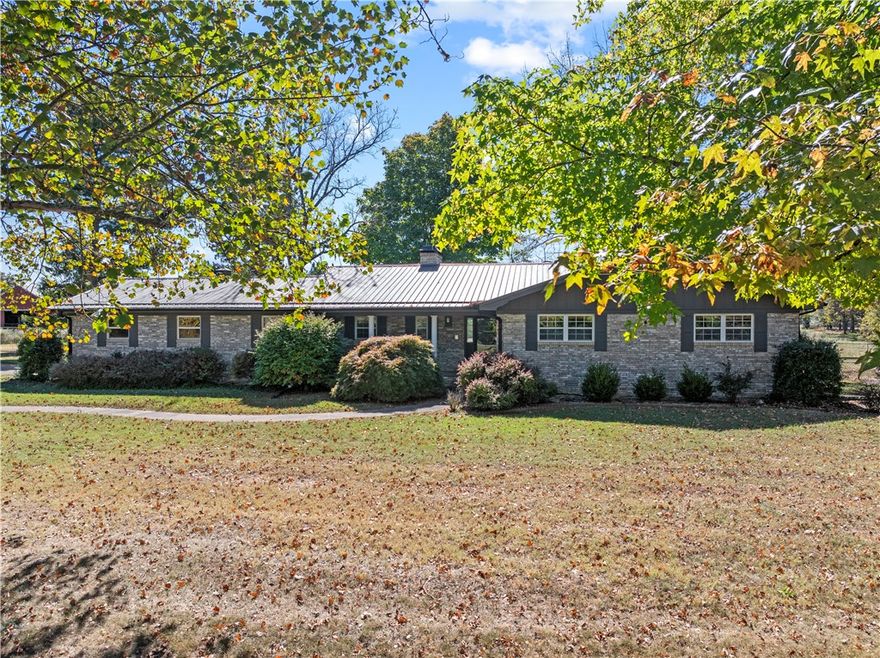 Opportunities like this don’t come around often—sixty flat, usable acres nestled in the heart of the Ozarks, complete with breathtaking views. This is a horse lover’s dream! The large metal barn includes two horse stalls, covered cattle working pens, and ample shelter for livestock. A fenced backyard dog pen ensures every member of the family—even the four-legged ones—feels right at home. The long, tree-lined driveway is peaceful and welcoming. Inside you’ll find a spacious living room and a large open kitchen/dining area, perfect for hosting family and friends. The sunroom is a great way to start the day, enjoying the view over a quiet cup of coffee. The finished basement offers flexible space—ideal for a kids' playroom, game room, or even a home office. The seller is including a $10,000 remodel allowance at closing, giving you the freedom to add your personal touch. Whether you’re looking to run livestock, start your homestead, or simply enjoy wide-open space with incredible scenery, this property delivers.