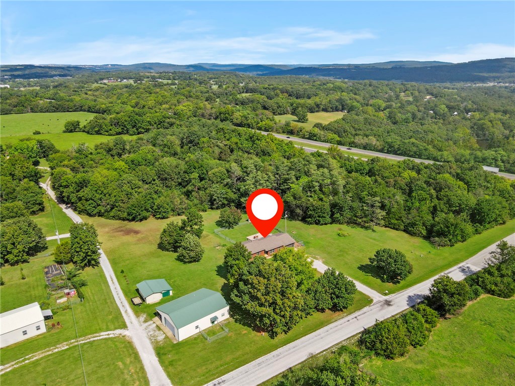 Rare opportunity with two homes on over 6 mostly cleared acres, just minutes from the University of Arkansas. The main residence offers flexibility with 4 bedrooms and 2 bathrooms—or configure as 3 bedrooms plus 2 offices. A wood-burning fireplace warms the spacious living area, and a large back patio is perfect for entertaining or relaxing. The detached second home is ideal as an income-producing rental or in-laws quarters. It features a large garage with plenty of storage, a generous 1-bedroom layout, a big living area, and 1 bathroom—providing both comfort and functionality. Enjoy privacy, versatility, and convenience, all less than 10 minutes to campus and Fayetteville amenities.