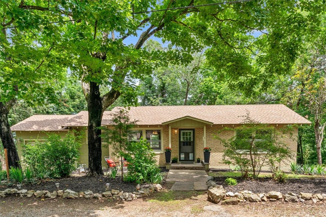 Experience the cozy, cool vibe of this delightful 2 BD brick home, brimming with mid-century charm and tucked away on a beloved dead-end street just off the historic loop. The location is IDEALājust a short walk to the lively, artsy downtown, offering the perfect blend of tranquility & local buzz. Whether you're loving your privacy by the warmth of the wood-burning stove or embracing the vibrant spirit of your diverse neighborhood by walking to the Crescent Hotel with a friend-this home offers a little bit of everything. Cool, original features abound, including stunning hardwood floors throughout and vintage built-ins that bring character to every room, like a charming pull-out ironing board in the kitchen and even a laundry chute to the basement laundry area. Plus, enjoy the peace of mind that comes with a brand-new roof installed in 2024. Ideal for a first-time buyer, savvy investor, or anyone seeking a peaceful retreat for part-time living or retirement. A perfect blend of community, comfort & character!