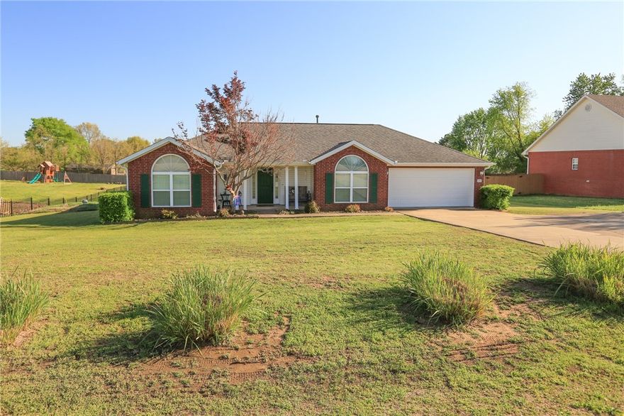 Nestled in the heart of Cave Springs, step inside and find a welcoming living room with a cozy gas log fireplace in the center. Followed by a beautiful kitchen with bright white cabinets, bright all matching white appliances and a bar top perfect for 2+ bar stools. Off the kitchen with access also from the front door, you'll find an office with a halfmoon window and tall ceiling. A split floorplan with a formal dining room/sunroom which leads to a newly added covered back deck. There's another covered grilling deck, a chicken coop, storage shed and plenty of room to enjoy the outdoors.  Feel safe knowing that there is a storm shelter just steps out the back door. Recent updates include a new water heater, with the roof and gutters replaced in 2019.  In the kitchen, gas is available if you’d prefer over the current electric stove. Ideally located just minutes from dining, shopping, parks, and growing community amenities, this home combines small-town charm with quick access to all that Northwest Arkansas offers.