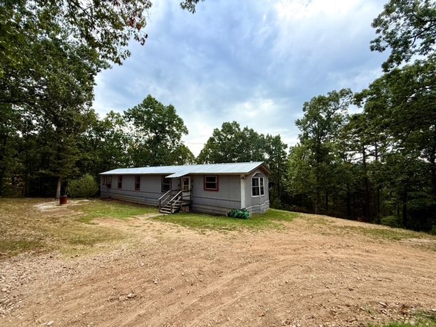 2BR 2BA, 1991 singlewide Mobile Home with a new metal roof, sits on 2 lots totaling 9.93 +/- acres. The property is on a quiet, well-maintained dirt road just off HWY 14 in Omaha. The property features a new circle drive, has zero restrictions, and has its own well and septic. With a large master bedroom and 5-piece master bath, just a few personal updates can make this move in ready home yours. Close to Branson, and both Table Rock and Bull Shoals Lake. The location is prime for all outdoors enthusiasts from hunting on your own land or taking the boat to the lake. All #'s are approximate and per seller. Buyer to verify.