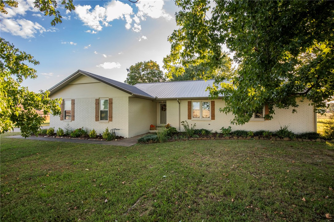 Tucked away on a flat 1.26-acre lot, this thoughtfully remodeled ranch offers the calm of the countryside with easy access to everything NWA has to offer — just 15 minutes from the new Walmart Home Office and 10 minutes to downtown Rogers and Springdale. Step inside to find a bright, open layout designed for modern living. Large windows fill the home with light and frame peaceful views of open land and mature trees. The fenced backyard and expansive deck make outdoor living effortless, whether you’re sipping morning coffee or watching cows graze in the neighboring pasture. The oversized 28’ x 38’ detached garage/shop includes power, a wood-burning stove, 50-amp RV service, outdoor hydrant, and an attached lean-to for extra storage. Recent updates include new metal roof, windows, doors, HVAC, water heater, and stylish cosmetic improvements. With its quiet surroundings, flat usable land, and modern comforts, this home delivers the best blend of privacy, convenience, and charm right in the heart of NWA.