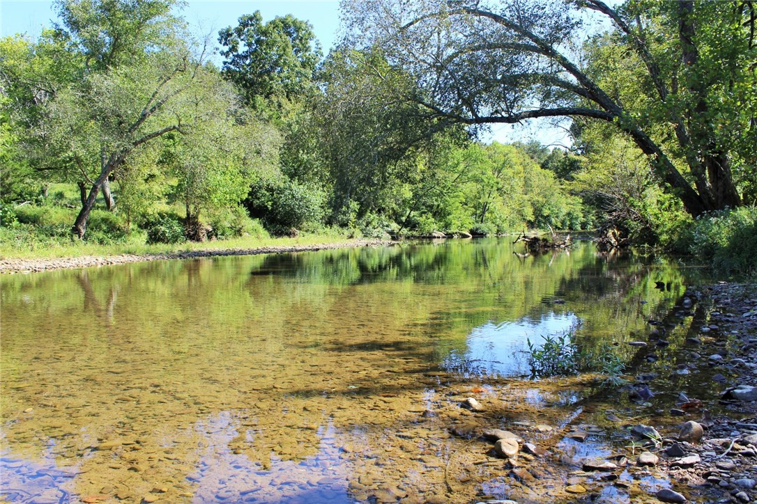 Located just 16 miles southeast of Huntsville, this 270-acre tract offers a rare combination of river frontage, open pasture, and recreational opportunity. Accessed via County Road 2545 and only 300 yards off Hwy 74, the property features approximately 3/4 mile of Kings River frontageāideal for fishing, kayaking, and waterfowl hunting. Currently used for cattle, the land also provides excellent wildlife habitat with frequent sightings of deer, turkey, and small game. Electric and rural water are already on-site, making it a great candidate for a homesite or cabin retreat. The north boundary includes a scenic bluff line offering panoramic views of the river and surrounding countryside. A conservation easement is in place to protect the natural beauty of the land. Whether you're looking for a working farm, recreational haven, or private getaway, this property is a standout in the Ozarks.