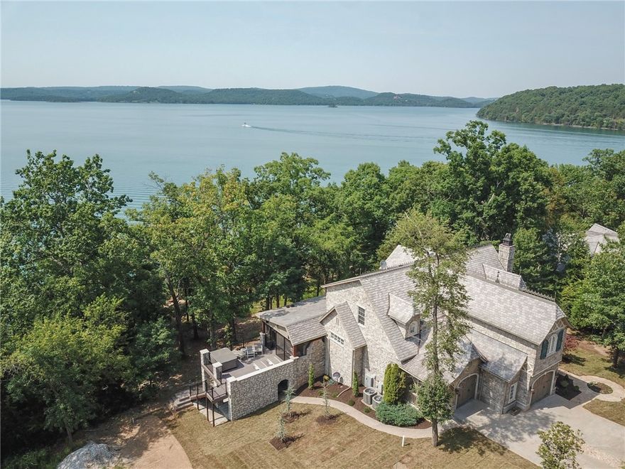 GATED Community Waterfront Lake Home includes 1 boat slip!  Step off your patio and walk GENTLY down to the lake to get on your boat and hit the water!  Big Open Water close to Rocky Branch Marina. This home has been completely remodeled to include 4 bedrooms 4.5 baths in the main home.  A sunroom with a relaxing view of the lake and gathering spot for your family! A fully completed guest suite in the basement that includes a full kitchen, bedroom, and bathroom.  Walk out to the covered screened in deck to enjoy a fireplace while you are grilling dinner at your outdoor kitchen.  Relax with a glass of wine in the hot tub over looking the water.  This home has surround sound, camera's, and more!  The perfect place to let your worries drift away.  The home is located in the gated community of Cotswold that features a community pool that is heated and a clubhouse to gather family and friends!