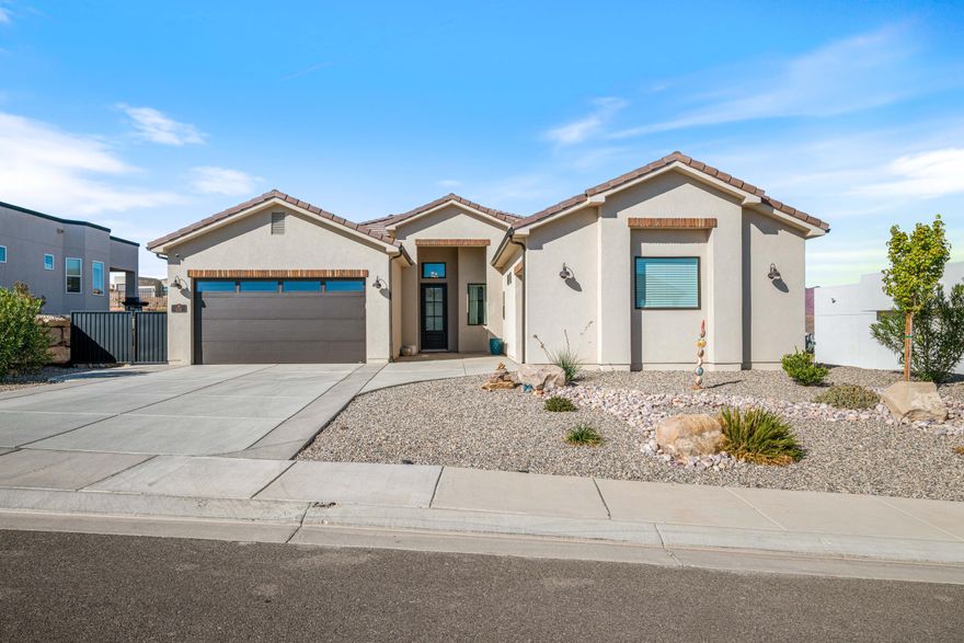 Set against sweeping Southern Utah views, this former model home in Divario delivers modern design, warm finishes, and an inviting sense of space. Tall ceilings, 8' doors, and seamless LVP flooring create a bright, open feel from the moment you walk in. The kitchen makes a statement with high-end quartz countertops, a waterfall island, full-height backsplash, under-cabinet lighting, and sleek slate GE appliances. In the great room, a custom fireplace with floating shelves pairs with oversized sliding doors that open to an extended epoxied patio—perfect for easy indoor-outdoor living. The primary suite enjoys its own slider to the backyard and a spa-inspired bath with tiled shower surrounds. Additional features include smart-home wiring, window coverings, an epoxied garage floor, and... the solid construction CareFree is known for, including 2x6 exterior walls. Move-in ready and situated in one of Divario's most scenic locations, this home offers a polished, elevated take on Southern Utah living.