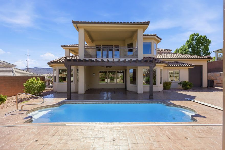 Discover timeless elegance in this stunning Tuscan-inspired villa nestled in Southern Utah's red rock landscape. This 6-bedroom, 4.5-bath home blends classic Old World charm--warm stone accents, arched details, and Mediterranean flair--with desert luxury living, featuring a grand entryway with smooth Venetian plaster walls that bathe the space in soft, reflective light, a main-level master suite with a spa-like walk-in shower and oversized custom closet, and a gourmet kitchen with premium stainless steel appliances ideal for entertaining. Outside, unwind in your private small  dipping pool under the Southern Utah sun, while the oversized RV/ 4-car garage offers abundant space for vehicles and adventure gear. This refined home delivers elevated Tuscan elegance in the heart of St. George.