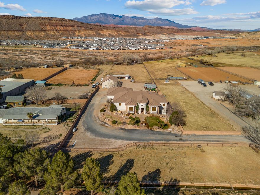 Your very own PRIVATE Virgin River Equestrian Estate on 2 ACRES with all your DREAM FEATURES, stunning VIEWS and the ultimate OUTDOOR LIVING. This fine LUXURY CRAFTED home is finished with engineered hardwood and travertine flooring throughout. The Main WALK-OUT BASEMENT Home is 5,800 sq. ft. w/ 6 bedrooms, 4 full bathrooms, & 2 half bathrooms & 2 large gathering areas. The Primary Owner Suite is on the MAIN LEVEL and the 2nd OWNER SUITE is in the basement. The spacious kitchen has 2 COPPER SINKS, Built-in APPLIANCES and GIANT HIDDEN PANTRY. The basement has a FULL 2nd KITCHEN, private THEATER with all the equipment, a 2nd LAUNDRY Room & several storage rooms. The detached GUEST QUARTERS / ADU is 600+ Sq. Ft. and comes with 1 Bedroom, 1 Bathroom, laundry area and full kitchen. The RV GARAGE is insulated with a mini-split system and includes a car lift.  Total garage space is 2305 Sq. Ft., so tons of parking for cars, trailers and toys.  This estate is ideal for hobby farm and very animal friendly w/  horse corrals, tack shed, and pastor w/ access to the Virgin River.  The BACKYARD OASIS includes a pristine SWIMMING POOL, hot tub, playground, full bathroom and BUILT-IN BBQ. 3,000 sq. ft. of COVERED PATIO space for beautiful views of Pinevalley Mountain, Virgin River and the Red Rock Candy Cliffs.