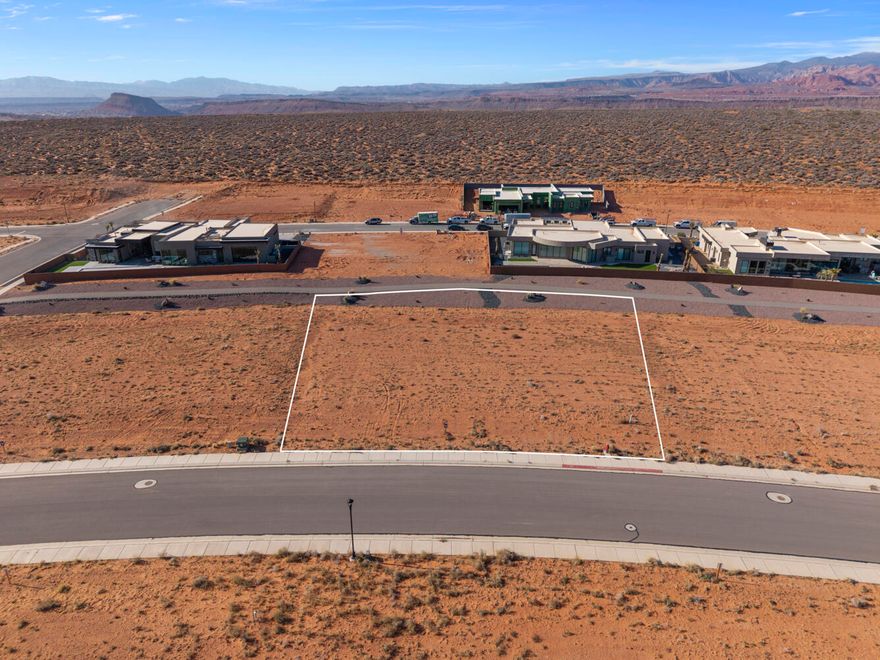 Build your luxury home on this .46-acre homesite in The Estates at Sand Hollow Resort, a premier golf course community anchored by a nationally ranked championship course. Backing to a walking path and surrounded by multi-million-dollar custom residences, this lot offers exceptional privacy, peaceful surroundings, and an ideal setting for a thoughtfully designed luxury home.
The generous lot size allows for expansive outdoor living, a private pool, and oversized garages, perfectly balancing refined living with Southern Utah's adventure-driven lifestyle. Enjoy striking desert landscapes, close proximity to championship golf, and effortless access to world-class recreation. Just minutes from Sand Hollow State Park and the iconic sand dunes, the location delivers seamless access to both resort living and year-round adventure.
Conveniently located 15 minutes from the airport and 1.5 hours from Las Vegas, this homesite is a must see. Ownership includes valuable homeowner benefits, such as front and backyard landscape maintenance for low-maintenance living. Choose from a list of Premier Builders or use your own developer-approved builder to bring your vision to life.