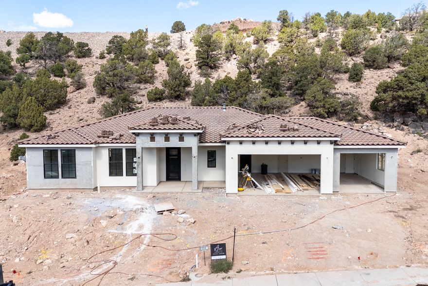 Nestled in Cedar City's prestigious Saddleback Ridge, this new construction home boasts stunning views amidst rolling, treed hills. This comfortable single-level home is 4 bedrooms and 2.5 bath with a 3-car garage. The open concept modern design mixes in Tuscan inspired touches to give it a comfortable, classic feel. The gourmet kitchen features custom cabinets, a hidden pantry, and an entertainer's island which flows nicely into an offset dining room. The fireplace and custom built-in cabinets give the living room a cozy touch. The master suite feels luxurious with beautiful tile work, a soaker tub, double sinks, and a huge closet. Enjoy outdoor living on the covered front AND back patios, perfect for relaxing and soaking in the views. Estimated Completion is October 2025.