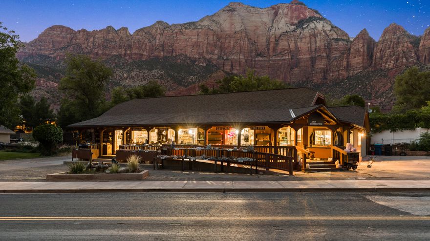 This is the rare opportunity to build your life and your business in Zion National Park. This profitable, well established Rock Shop (it has been a rock and gem shop for over 20 years) offers prime frontage, high visibility, and the freedom to live where you work in the vibrant town of Springdale, Utah. The property includes approximately 1,719 square feet of commercial space with good strong financials. Attached is a 1,646 square foot 3 bedroom 2 bath private apartment, ideal as an owner's residence, staff housing, or an additional rental unit. There's also a 60 square foot basement for storage, and the property sits on a 0.30-acre lot with on-site parking, this setup is flexible and functional. The location sees millions of visitors passing by each year. Whether you want to continue the rock shop tradition or launch your own concept, the infrastructure is in place. The current manager welcomes the continuation of managing the business as it stands. This can help ensure stability of an ongoing business and offers the potential to develop a strong social media presence as well. Wake up every day to towering red cliffs, glowing skies, and a built-in audience just outside your door. If you've been waiting for a sign to step into a new chapter, where your business is fueled by the energy of Zion and your backyard feels like a national treasure, this is it.