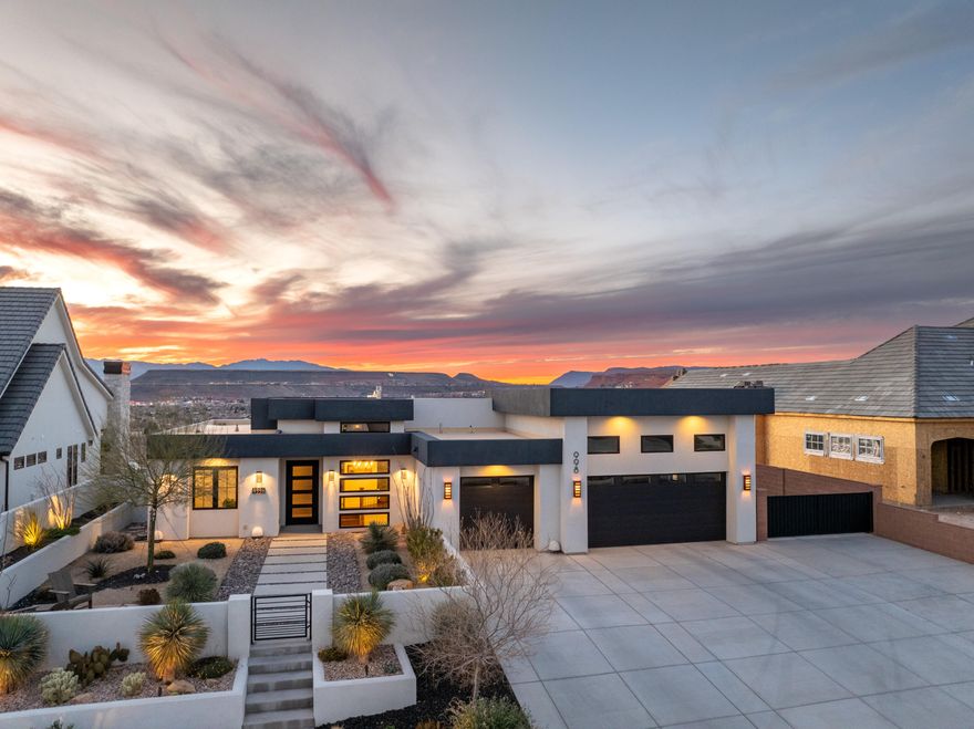 This gorgeous home was built and designed to impress with an open floor plan and breathtaking views, perfectly perched on South Rim at Foremaster. The kitchen features 12' ceilings, a large island, upgraded appliances, and endless views from the window. The living room showcases dramatic floor-to-ceiling windows beneath soaring 11' ceilings, while the entry rises to 13'. A stunning 10-panel folding glass door functions as both a standard door and an accordion system, opening to a wide 10-foot span for seamless indoor-outdoor living. The home offers 5 bedrooms, including two primary en-suites - one with an 11'-13' tray ceiling, and 5.5 bathrooms. Step outside to a backyard oasis with a large inground pool featuring a baja shelf, two umbrella stands, and an extra-large spa that seats 8. Enjoy covered patios and an expansive deck with unobstructed views of downtown St. George, Tech Ridge, Red Mountain, and the distant Utah mountains. Exterior highlights include fully fenced and landscaped yards, a gated driveway perfect for trailers, and a spacious courtyard with a raised stucco planter and water feature. Low-maintenance xeriscape includes a 10-foot saguaro cactus, drip irrigation, and a tiered front yard. Additional features include an oversized 3-car garage with epoxy floors and a steel front door with a convertible glass panel. No HOA, minutes to Intermountain Hospital and downtown St. George.