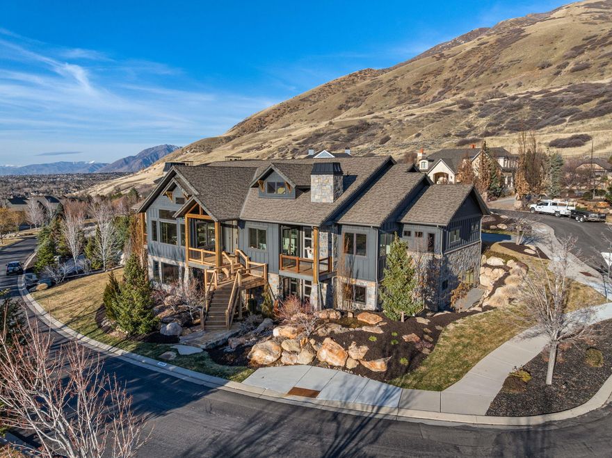 Positioned within the highly sought after Steeplechase community, this stunning former Parade Home offers refined living surrounded by sweeping mountain and valley views. Designed for both elegance and comfort in mind, the home showcases impressive architectural details, expansive windows and beautifully curated living spaces filled with natural light. The main living area features soaring ceilings and dramatic wall of windows that highlight the surrounding scenery. A spacious gourmet kitchen anchors the home, complete with custom cabinetry, large island and high end finishes create a space that is both functional and elegant. The primary suit provides a peaceful escape, offering generous space, oversized windows, fireplace and a beautifully designed spa inspired ensuite bath featuring dual vanities, soaking tub, an oversized shower and large walk in closet. The lower level is designed for entertaining with a second kitchen, family room, expansive theatre room and a dedicated gym. Step outside to a covered patio featuring an outdoor fireplace & outdoor kitchen, creating an inviting space to gather while taking in the sweeping mountain views and surrounding natural beauty. Offering a rare combination of design, comfort and breathtaking scenery, this exceptional property presents an opportunity to experience elevated living in one of the areas more desirable neighborhoods.