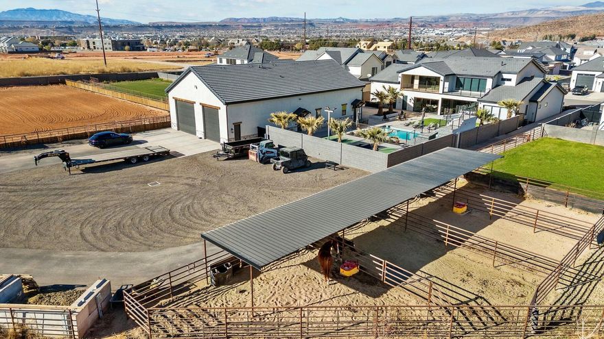 Discover a one-of-a-kind estate in Washington Fields, ideal for your dream homestead. Set on 2.29 acres with horse privileges, this custom home features ensuite bedrooms, walk-in closets, and high-end finishes. A 3,520 sq ft barndominium-style garage—heated, air-conditioned, and equipped with a bathroom, TV, and sink—offers versatile living and workspace but is not included in the home's finished living space, and can be converted into an apartment. Enjoy a roping arena, four stalls, two irrigated pastures, pool, pickleball court, and trampoline. The fields and arena can be transformed into a sports arena, batting cages, or anything you envision. No HOA—appraised at $4.16M.