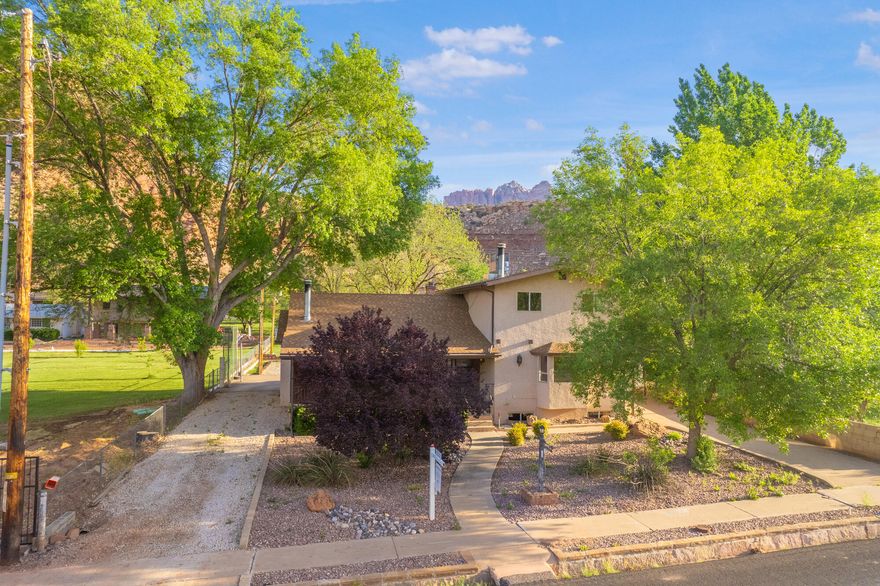 Rockville Homestead: .98 Acres of Opportunity Near Zion

Located on a lush, fully fenced .98-acre lot just minutes from the gates of Zion National Park, this estate offers a rare combination of space and self-sufficiency. The property is a productive homestead, featuring 1.5 shares of Rockville Town Ditch Company irrigation water with a clever hybrid system that utilizes both flood and pressurized lines for the garden and grounds. With horse privileges and a gravel parking area for trailers or equipment, this property is perfectly suited for a classic Southern Utah lifestyle.

The residence is a sturdy, light-filled sanctuary featuring six bedrooms and three-and-a-half bathrooms.While the home retains its original character, the essential infrastructure updates have been completed, including a new roof, new heating and cooling systems, and fresh carpet. The functional layout offers two separate family roomseach with a wood-burning fireplaceas well as a dedicated office and a creative craft area.

Practicality is found in every corner, from the abundant storage to the large laundry and mudroom that serves as a transition from the outdoors. The grounds are already optimized for small-town living, complete with a chicken coop and run, a storage shed with a workbench, and mature pecan, apple, and pear trees. This is a rare opportunity to secure a high-utility property in Rockville that is move-in ready today, while offering the "good bones" and water security needed to build significant equity as you customize it over time.