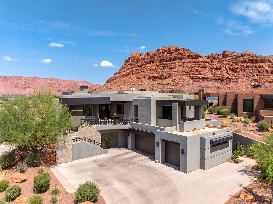 Magnificent unobstructed views of the red mountains and the entire valley—seen through expansive windows across the rear of the home. The open-concept layout is bathed in natural light, featuring formal and casual dining spaces, and seamless indoor-outdoor living. The chef's kitchen is a true masterpiece, boasting high-end quartzite and granite countertops, built-in Wolf and Bosch appliances, a heat lamp shelf, microwave drawer, oversized sink, wine chiller, and a food and butler's pantry. The spacious primary suite boasts an automatic Hunter Douglas shade, a cozy gas fireplace, and custom LED lighting. The en-suite bathroom features a garden tub, a three-head shower system (rain, handheld, and body sprays), and a boutique-style walk-in closet complete with custom cabinetry, jewelry inserts, a built-in safe, and ironing station. Guests will enjoy privacy and comfort in the attached casita, complete with a separate entrance, kitchenette, and en-suite bathroom with a walk-in shower. Features throughout include remote control shades, low voltage lighting, alarm system, central vacuum, HVAC, and Flow by Moen water monitoring. Step outside to your private resort-style backyard featuring a sparkling saltwater pool with spa, waterfall, and misters. The expansive patio includes an outdoor fireplace, built-in BBQ, and professional landscaping.  Oversized 3-car garage with epoxy floors, built-in shelving, a large storage room (15x11 ft), a dog wash station, and a built-in workbench. A convenient elevator connects the garage to the main level, perfect for transporting groceries, luggage, or avoiding stairs altogether. This home includes all TVs, refrigerator, washer, and dryer. A rare combination of luxury, technology, and tranquility this is desert living at its finest.