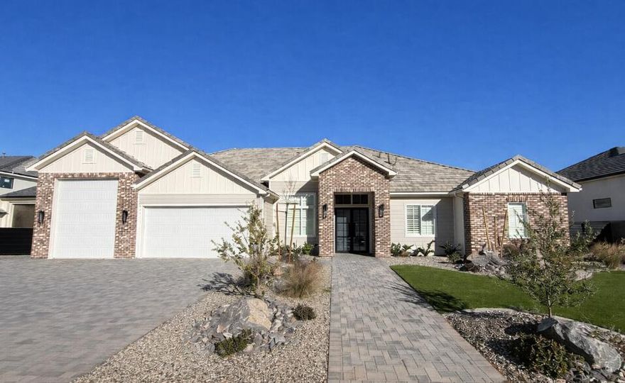 Stunning lightly lived in New Trend Construction home ideally located in desirable Sycamore Village neighborhood, 7 minutes from Sand Hollow State Park! Boat garage with epoxy flooring. Open floor plan with 10'+ ceilings throughout, big picture windows to bring in natural light & every bedroom includes its own en-suite bathroom, providing privacy and comfort for family and guests alike. Chef's kitchen upgraded with oversized fridge & freezer, GE Cafe appliance package, range hood & large walk-in pantry. Luxurious primary suite with blackout blinds, dual vanities, extra cabinetry, free-standing tub & walk-in shower creating a spa-like atmosphere. Other upgrades include motorized blinds, plantation shutters, hardwood flooring, designer tile, quartz countertops, custom millwork/cabinetry & ample storage. This home provides beauty, comfort, luxury & practical living.