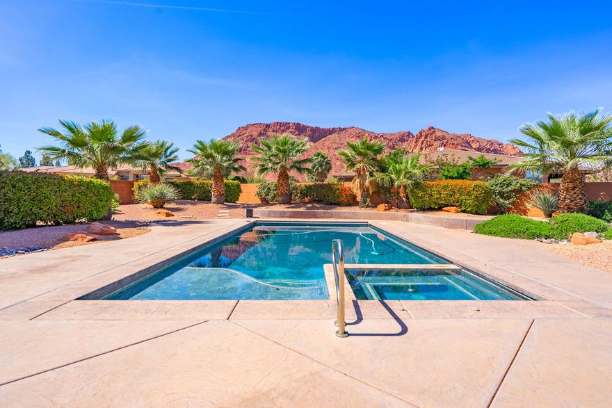 Welcome to this 3,386 SF single-level residence which showcases exceptional craftsmanship and some of the most sought-after views in Southern Utah. From the solid Acacia wood flooring (one of the hardest and most durable woods available, naturally moisture-resistant and visually striking) to the solid knotty alder wood doors, custom knotty alder cabinetry, and exquisite stonework throughout, every detail reflects quality construction and thoughtful design.

Soaring ceilings and expansive windows in the living room frame unobstructed views of the red rock mountains while surrounding a beautiful fireplace. Just beyond, the private pool, spa, outdoor BBQ, and tranquil water feature create a seamless extension of the indoor living experience. With the inclusion of the private pool, the zoned HVAC system ensures elevated comfort year-round, enhancing both efficiency and livability.

At the heart of the home, the gourmet kitchen continues the theme of thoughtful craftsmanship. A double-island layout provides generous workspace and effortless flow, while abundant storage, a walk-in pantry, and a dedicated wine/beverage room elevate both everyday convenience and entertaining potential.

For outdoor enthusiasts, the location is unmatched. With approximately 29 scenic hiking and biking trails in the immediate area, many accessible directly from the surrounding Red Cliffs Desert Reserve and nearby Snow Canyon State Park, you're steps away from world-class recreation. Popular options include the Padre Canyon Trail, Johnson Canyon Arch Trail, and the Whiptail Trail, along with notable destinations such as the Anasazi Valley Trailhead for viewing ancient ruins and the Chuckwalla Trail leading to Scout Cave.