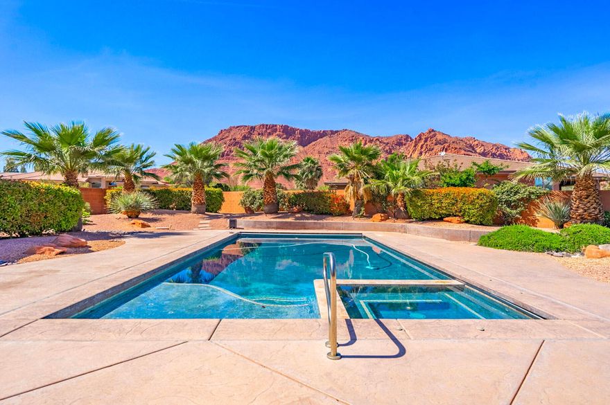 Welcome to this 3,386 SF single-level residence which showcases exceptional craftsmanship and some of the most sought-after views in Southern Utah. From the solid Acacia wood flooring (one of the hardest and most durable woods available, naturally moisture-resistant and visually striking) to the solid knotty alder wood doors, custom knotty alder cabinetry, and exquisite stonework throughout, every detail reflects quality construction and thoughtful design.

Soaring ceilings and expansive windows in the living room frame unobstructed views of the red rock mountains while surrounding a beautiful fireplace. Just beyond, the private pool, spa, outdoor BBQ, and tranquil water feature create a seamless extension of the indoor living experience. With the inclusion of the private pool, the zoned HVAC system ensures elevated comfort year-round, enhancing both efficiency and livability.

At the heart of the home, the gourmet kitchen continues the theme of thoughtful craftsmanship. A double-island layout provides generous workspace and effortless flow, while abundant storage, a walk-in pantry, and a dedicated wine/beverage room elevate both everyday convenience and entertaining potential.

For outdoor enthusiasts, the location is unmatched. With approximately 29 scenic hiking and biking trails in the immediate area, many accessible directly from the surrounding Red Cliffs Desert Reserve and nearby Snow Canyon State Park, you're steps away from world-class recreation. Popular options include the Padre Canyon Trail, Johnson Canyon Arch Trail, and the Whiptail Trail, along with notable destinations such as the Anasazi Valley Trailhead for viewing ancient ruins and the Chuckwalla Trail leading to Scout Cave.