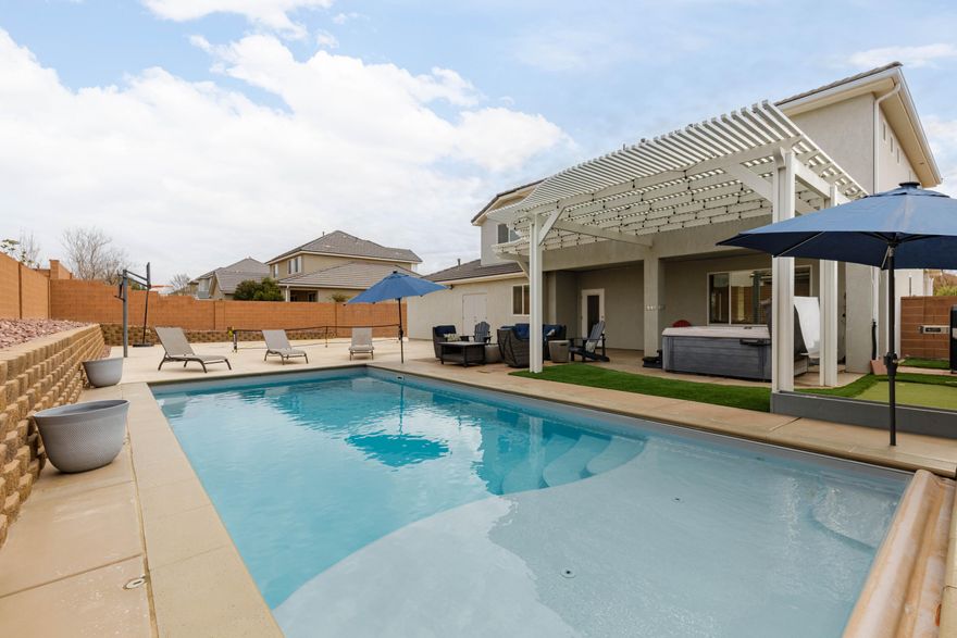 Ideal Little Valley home with backyard built for both function & fun featuring a heated saltwater pool, hot tub, oversized concrete pad perfect for pickleball or basketball, putting green, & dedicated concrete RV parking. All concrete is rebar-reinforced for added durability. The functional tandem three-car garage includes a third garage door providing direct access to the backyard & parking area, along with an extended driveway for additional vehicle parking. Inside, timeless finishes include stunning cabinetry, quartz countertops, ample pantry, & generous storage throughout. The primary suite offers a sleek freestanding tub, walk-in shower with stone floor, & dual vanities. Bedrooms are generously sized with accent walls & upgraded closets. Home also has a second family room upstairs.