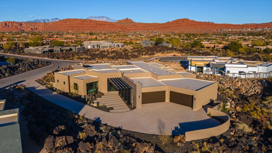Perfectly situated among basalt rocks at the base of Snow Canyon inside Entrada Golf & Country Club, this brand-new custom home captures stunning red rock and mountain views. The great room features a striking fireplace wall, expansive windows, and views of a private backyard with heated pool, spa, outdoor fireplace, built-in BBQ kitchen & TV hookups. The chef's kitchen offers Riverwoods Mill cabinets, Wolf/Subzero appliances, waterfall island, butler's pantry, and hardwood floors. The primary suite includes a luxury bath, gym, spacious closet with W&D and private patio access. Additional features: office, casita, ensuite bedrooms, 4-car garage w/ EV charger, Crestron Home automation, motorized shades, solid wood doors and so much more! 
Buyer to verify all information.