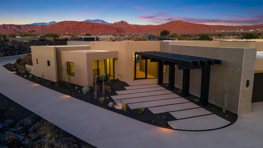 Perfectly situated among basalt rocks at the base of Snow Canyon inside Entrada Golf & Country Club, this brand-new custom home captures stunning red rock and mountain views. The great room features a striking fireplace wall, expansive windows, and views of a private backyard with heated pool, spa, outdoor fireplace, built-in BBQ kitchen & TV hookups. The chef's kitchen offers Riverwoods Mill cabinets, Wolf/Subzero appliances, waterfall island, butler's pantry, and hardwood floors. The primary suite includes a luxury bath, gym, spacious closet with W&D and private patio access. Additional features: office, casita, ensuite bedrooms, 4-car garage w/ EV charger, Crestron Home automation, motorized shades, solid wood doors and so much more! 
Buyer to verify all information.