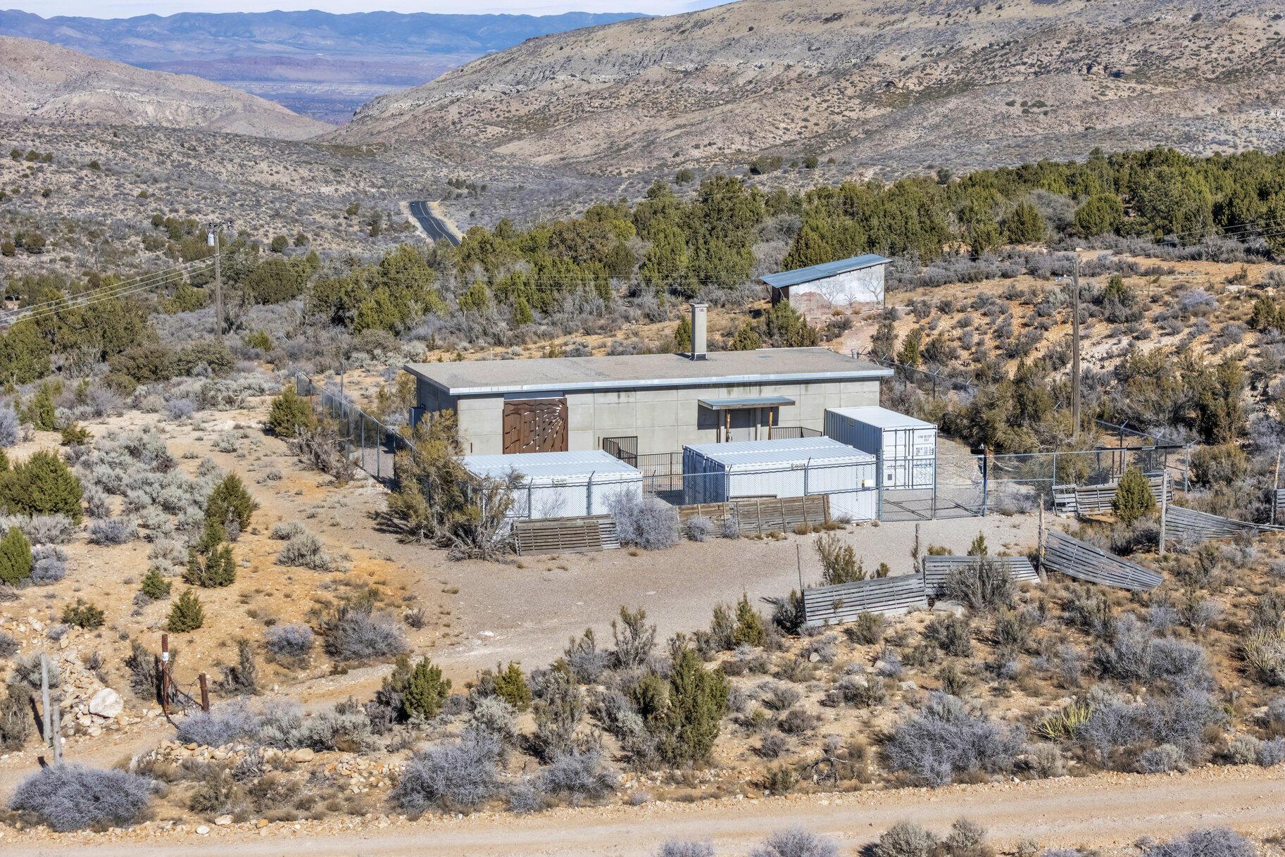 This is a unique property: a MILITARY BUNKER! Nestled amidst BLM land, it offers stunning views and access to miles of 4x4 trails. The structure boasts 10-foot ceilings, walls, and floors all reinforced with 2 feet of high-density concrete. Features include heavy-duty wiring, an efficient heat pump, a 3,000-gallon cistern, and a military-grade outhouse. Designed to withstand an A-bomb explosion. Also included is a separate acre with a decommissioned, government-designed secure concrete communication building. Also include 1 acre parcel # 9061-B-NP next to this property.