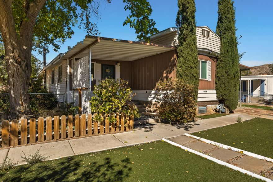 Now showing and now available. This beautiful mobile home, on its own lot, with no HOA, in LaVerkin, UT is only 21 miles from Zion National Park. This home is 1,960 sqft, 2 bed, 2 bath, flex rooms, living/family room, wood burning stove, with a covered carport, on 0.14 acre corner lot. Beautiful mature trees and easy maintenance turf landscaping. Refrigerator is included. New roof shingles recently. Great detached storage/workshop area in the back. Excellent enclosed storage area underneath. This is a a great starter home, second home or investment property. Close to grocery, gas, restaurants and so much more. Don't forget to check out the La Verkin Hot Springs. This is the gateway to Zion National Park. Schedule your showing today.