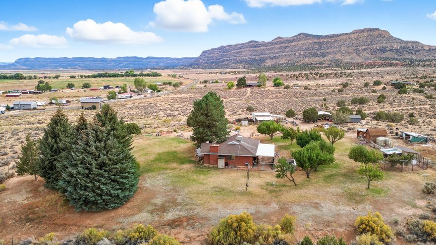 Just one mile south from Center and Main in Escalante, this 6.21-acre property offers space, self-sufficiency, endless potential, and MILLION dollars views in EVERY direction! The 5-bedroom, 3-bath home spans 2,716 sq. ft. providing a functional layout with plenty of room for family and guests. A $35k solar system with backup storage batteries (fully paid off) keeps utility costs low and adds long-term value. The property includes multiple outbuildings and a large shop equipped with 220 power and a fire stove, plus attached covered storage and parking. Several additional shelters provide protection from the elements and versatile storage options, large chicken coop, while fenced raised garden beds make it easy to grow your own produce. Culinary water to home is on city of Escalante water, Water share for irrigation is part of Escalante Irrigation company, and 50% mineral rights add to the property's unique offerings. Included in the sale are a golf cart, tractor with three separate attachments that help with operations on the property, and a variety of outdoor equipment, making the property truly turnkey. With wide-open views and the convenience of being just minutes from town, this property is perfect for anyone looking for space to spread out, work on projects, and enjoy the best of country living.