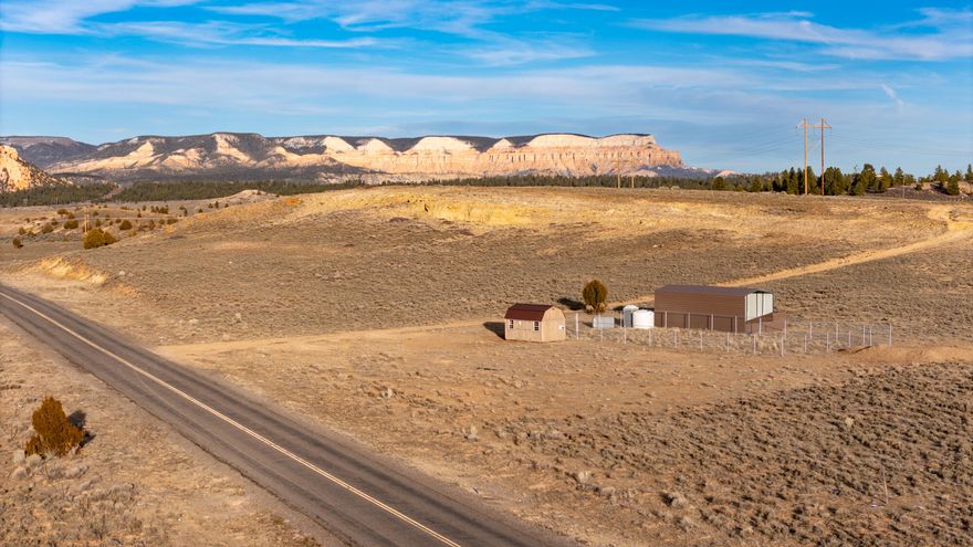 Exceptional opportunity to acquire 68 acres located just off Highway 12 and John's Valley Road. This highly visible property sits within Southern Utah's active tourism corridor and offers convenient access to the area's major national parks, along with nearby hiking, ATV trails, and year-round recreation.  Currently zoned Agricultural, the property presents strong future development potential, including the possibility of rezoning to Commercial through planning and zoning. The acreage borders Bryce Canyon City and may be eligible for annexation into city limits, further expanding potential development opportunities. With similar commercial properties already established along Highway 12, this parcel is well suited for a variety of uses, including a hotel, lodge, RV park, or tiny cabin development. The land also includes multiple functional outbuildings that support agricultural and operational use. Improvements include a metal-covered equipment/storage structure, a wood-sided shed with windows, and additional utility structures, all situated within a fenced area for added organization and security. These features enhance the usability of the property and offer flexibility for continued agricultural use or future development planning. This is a rare opportunity to own a large, versatile parcel in one of Southern Utah's most desirable destination areas.
(Seller will carry note with $500k down.  Terms negotiable.)