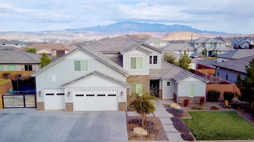 This beautifully finished home highlights an open-to-below family room with a 20' ceiling that fills the space with natural light and creates a stunning sense of openness. Thoughtful finish work throughout showcases quality craftsmanship and timeless design. The 6th bedroom could also be an office or additional room on the main level.  RV parking on the side of the home in addition to the epoxy finished 3 car garage allows for all of your parking needs. Additional family room upstairs is enclosed allowing for all the noise to be captured behind closed doors! Great location close to schools, airport, lakes, and all the great things St George has to offer!