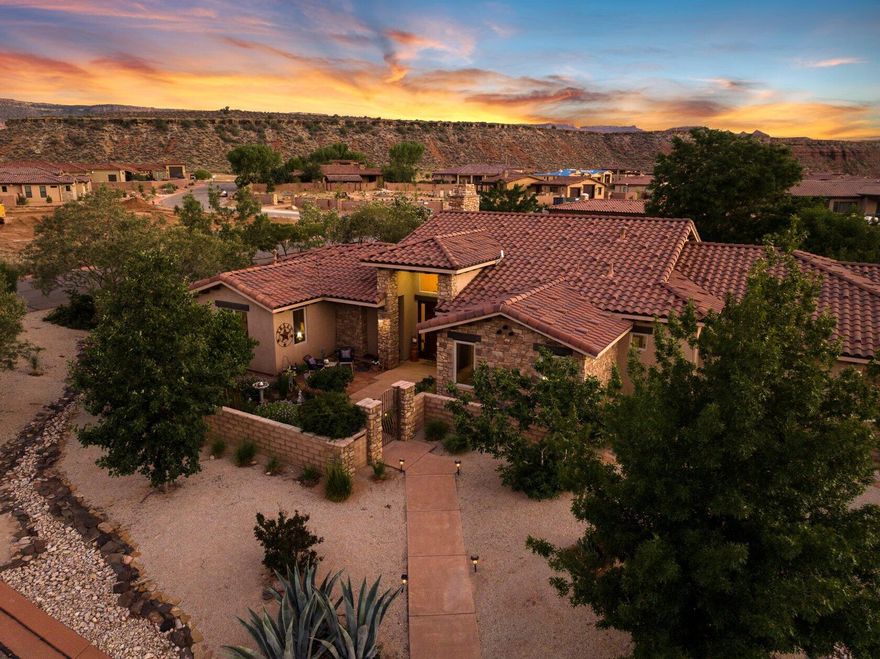 Nestled on over half an acre in the charming town of Virgin, Utah—just moments from the splendor of Zion Canyon—this custom-built residence offers a refined blend of indoor comfort and outdoor beauty. Beyond the private gate, a landscape of fruit and nut trees, raised garden beds, and curated desert flora invites you to slow down and savor the seasons. Whether you're harvesting fresh figs for a summer tart or gathering herbs for a winter roast, the land here is as purposeful as it is picturesque. Inside, the 2,466-square-foot floor plan is graciously laid out, featuring three spacious bedrooms and three bathrooms—including two generous primary suites designed for rest and rejuvenation. High ceilings, natural light, and quality finishes throughout create a warm, welcoming atmosphere perfect for both quiet evenings and festive gatherings.

The oversized garage including a separate workspace and storage room, provides ample space for storage and hobbies, while the nearby trails and canyons offer endless opportunities for exploration. Whether you're preparing fresh pasta in the well-appointed kitchen or enjoying morning tea on the patio with views of red rock cliffs, every moment in this home is a celebration of comfort, style, and simple pleasures.