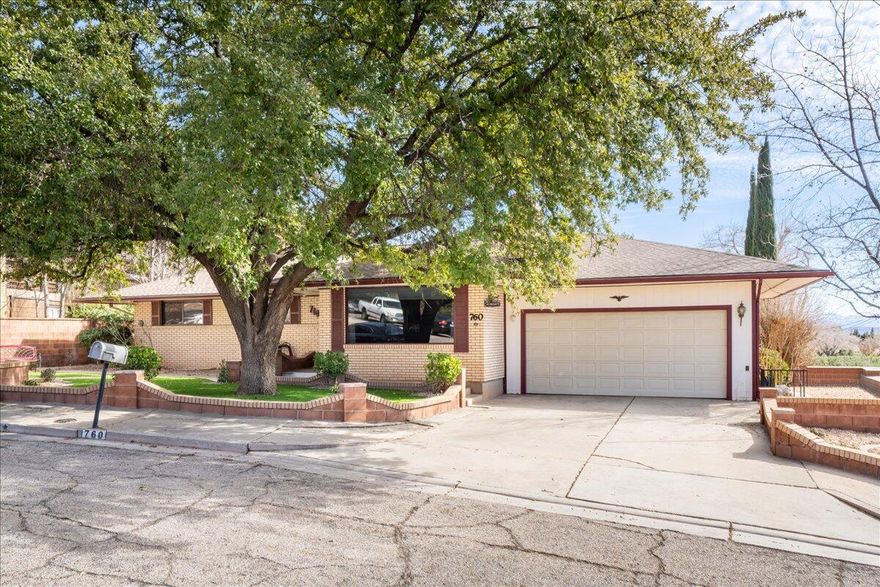 Located in the heart of St. George, this spacious 6 bedroom, 3 bathroom home offers room to spread out, settle in, and truly make it your own.

Tucked along a quiet street with mature shade trees and classic brick curb appeal, this home blends character with functionality. The main level features a warm and inviting living room with rich wood flooring and a striking floor to ceiling stone fireplace that anchors the space beautifully. Large picture windows bring in natural light and neighborhood views.

The kitchen offers abundant cabinetry, generous counter space, stainless steel appliances, and an open dining area with sliding glass doors leading to the backyard, making indoor outdoor living easy and accessible.

Upstairs you will find three well sized bedrooms, including the primar suite with its own en suite bath. Downstairs, the fully finished basement adds incredible flexibility with three additional bedrooms, a third bathroom, and a spacious second living room with a cozy fireplace and recessed lighting. Whether you need guest space, a home office setup, hobby rooms, or multi generational living, the layout provides options.
Outside, the private backyard includes a covered patio, terraced planter beds, mature trees, and a storage shed. With red rock views peeking over the wall, the setting feels distinctly Southern Utah.
A dedicated laundry room, ample storage throughout, and a two car garage add everyday convenience.
Just minutes from parks, schools, shopping, dining, and downtown St. George, this centrally located property delivers square footage, versatility, and opportunity in one of the city's most established neighborhoods.
If you are looking for space in a prime St. George location, this one deserves a closer look.