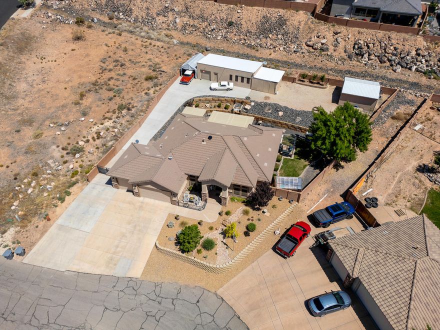 Buyer Bonus - Use our preferred lender and receive 1% of the purchase price towards a rate buy down.

WORKSHOP - WORKSHOP - WORKSHOP 20x40 heated and cooled plus another garage and tons of parking. This spacious .38 acre lot   with Incredible Views, AND ample room for all your toys is a dream come true!

This dream property is tucked away in a quiet cul-de-sac in Hurricane! The beautifully maintained 4-bedroom, 3-bath home also features a DEDICATED OFFICE—perfect for remote work or hobbies. Set on a generous .38-acre lot, the property offers breathtaking red cliff views and twinkling city lights from the backyard, creating the... perfect outdoor retreat.

The xeriscaped front yard provides low-maintenance curb appeal, while the backyard includes a grassy areaideal for pets and keeping things cool in the warmer months.

You'll love the massive 20x40 workshop equipped with 100-amp service, 110/220 volt electrical, and its own mini-split system for heating and cooling. Plus, there is covered storage on the side of the shop as well as the 20x20 garage/storage building. The shop does not have water but access is close by. The HOA fee is only $22 but it is in the process of being dismantled so there will be no HOA or transfer fee.
Recent upgrades include:
New carpet and fresh interior/exterior paint
New range/oven and microwave
New patio covers
Greenhouse (can stay or go)
New insulation above the garage
Whole house fans & solar attic exhaust fan
Sealed ductwork for improved energy efficiency

With TONS of parking, room to roam, and thoughtful energy-saving features, this property offers a rare blend of comfort, convenience, and functionality. Call today to schedule an appointment. It's occupied but easy to show. Buyer and Buyers agent to verify all information.