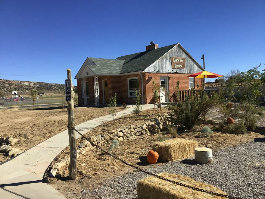 Formerly the Ranch Dog Kitchen, this 1930's era commercial space has all the charm of years gone by, while tastefully modernized for the 21st century.
Ideally located along the iconic Highway 12 Scenic Byway, in the heart of Escalante and the Escalante Grand Staircase Monument, this Main Street property is the ideal spot for someone looking to bring their small business to this charming little town.
The options are endless with this space-  restaurant, art gallery, short term rental, etc.
Space includes a two bedroom basement with kitchenette for owner or employee housing.
Upstairs is the high end commercial kitchen, serving/dining area, and bathroom, with room to expand if needed. Outside is cozy dining or gathering area with covered seating that has also doubled as a stage for town music festivals.