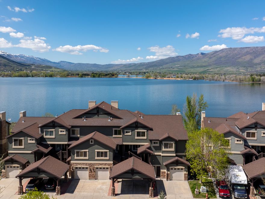 Enjoy lakeside living in this beautifully maintained 2-bedroom, 2-bathroom condo perfectly positioned on the shores of Pineview Reservoir. Offering a seamless blend of comfort and convenience, this residence is being sold fully furnished, making it a true turnkey opportunity for full-time living, a vacation getaway, or investment potential. Step inside to find a warm and inviting open-concept floor plan featuring a spacious kitchen with stainless steel appliances, knotty alder cabinetry, and slate tile flooring. The adjoining living area with a cozy stone fireplace, and direct access to a private deck where you can relax and take in the lake and mountain views.  All property information, boundaries and documents to be verified by buyer.