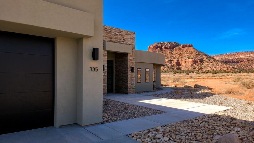 Nestled in the breathtaking landscape of Kanab, Utah... just below the majestic red mountains, lies a luxury desert oasis that redefines the essence of high-end living. This stunning property is a masterpiece of modern design, seamlessly blending into the surrounding natural beauty.

As you approach the property, you are greeted by the serene ambiance of the desert landscape.  Minimal landscaping and Xeriscape is used to retain the natural beauty of the native plants and history. The exterior design features clean lines, minimalist aesthetics, and an abundance of glass, allowing the stunning red rock formations to take center stage. 
Upon entering the property, you will be struck by the elegance of the open concept living area features such as soaring ceilings, walls of glass, and seamless transition between indoors and outdoors. Beautiful wide plank hardwood floors and porcelain tile throughout the home. The gourmet kitchen is a culinary dream, equipped with high- end appliances, sleek cabinetry, and expansive quartz countertops. just behind the main kitchen is a serving kitchen with sink where you have more room for food preparation. This serving kitchen leads to a large pantry ... with views from the pantry as well.

Imagine waking up in the spacious primary suite with these exceptional red mountain views. Large glass sliding doors lead from the primary suite to the private back patio where you can enjoy your morning coffee or walk right out to one of many walking paths or the BLM hiking trail behind the community.
Tucked away from the main living area, the second primary suite offers a serene retreat for guests with a separate entrance and kitchenette. 
Enjoy breathtaking views of the surrounding red rock formations, creating a sense of connection to the natural beauty Kanab is famous for. As the sun sets, the sky is painted with hues of pink, orange, and purple... making this a truly unforgettable destination.
This home offers 2 temperature-controlled zones. Oversized 2 car garage and 44ft RV garage also has a trailer clean out.  No expense was spared in the garage with epoxy coating on the floors as well. 

This particular home offers a unique investment opportunity, as it is one of the few lots in the community zoned for Short Term Rental use.  With access to amenities like pools, pickleball courts, hot tub, and playground... this property is poised to generate significant rental income. Out of 147 lots, only 7 will be allowed to be zoned as short term rentals and have access to the amenities in the gated community next door.  This is one of those lots. It is not required... but is an option should the owner choose to use it as such.
This luxury desert oasis is a rare find, offering the perfect blend of natural beauty, modern sophistication, and outdoor recreation. Whether you are seeking a private retreat, an adventure-filled getaway, or a lucrative investment opportunity, this is property is sure to exceed your expectations.
FURNISHINGS ARE INCLUDED