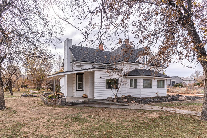 This home has been standing here since 1914, and it shows in all the right ways. It's been updated, but the floors still creak a little, because honestly, you'd miss it if they didn't. Just under 2,000 square feet on a .34-acre lot, right in Hurricane, where porch swings are normal, gardens matter, and neighbors actually know each other. Five bedrooms, two baths, a primary on the main level, and two living spaces give you room to settle in and make it your own. The yard is full of mature trees, including a pecan tree that's seen generations come and go and probably has a few stories of its own.