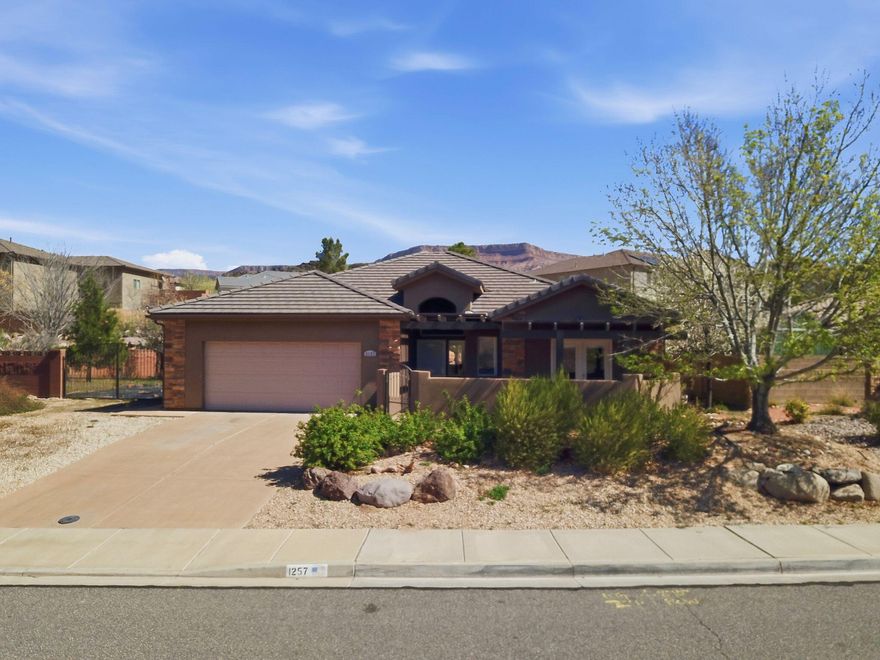 Welcome to this beautiful single-story home in the desirable Trail Ridge Estates community in Toquerville. Featuring an open floor plan with tall ceilings, abundant natural light, and neutral finishes, this home is perfect for everyday living and entertaining. The kitchen boasts granite countertops, double wall ovens, a gas cooktop, and a walk-in pantry. The backyard shines with low-maintenance turf, mature trees, and dramatic boulder retaining walls. Located directly across from City Park and a walking trail along La Verkin Creek, with easy access to St. George, Zion National Park, and outdoor recreation.